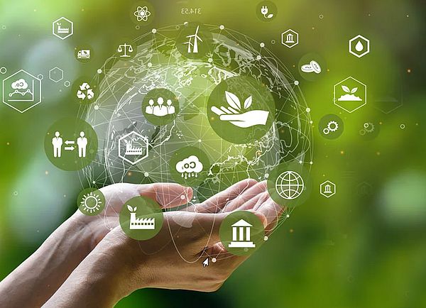 Zwei Hände halten einen vituellen Erdball mit Kreislaufwirtschafts-Symbolen