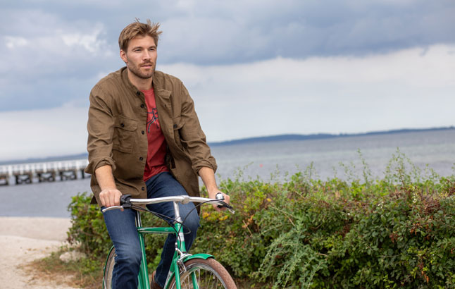 Mann auf Fahrrad am Meer