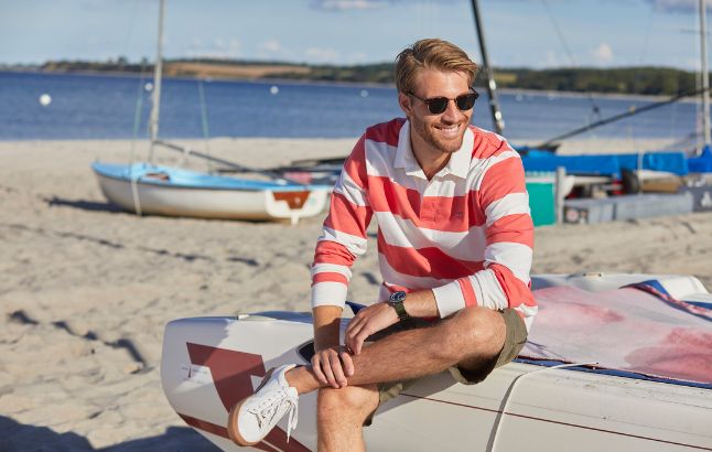 Mann in sommerlichem Langarm-Polo am Strand