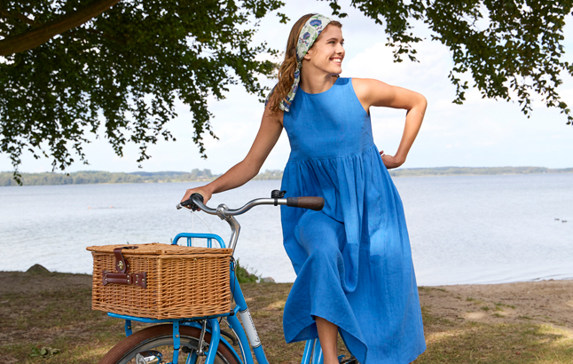 Frau im blauen Kleid auf Fahrrad