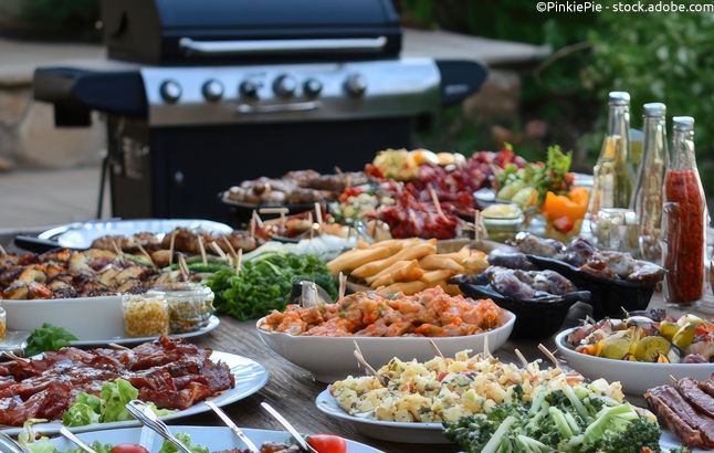 Gerichte und Grillsaucen mit Grill im Hintergrund