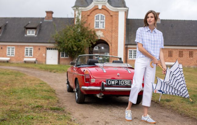 Frau vor rotem Cabrio