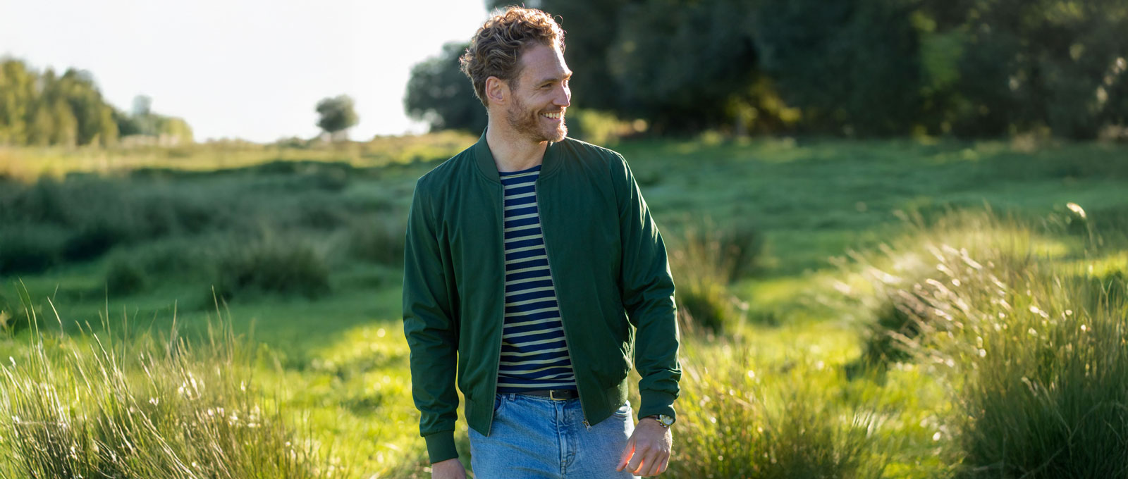 Mann vor üppiger grüner Wiese