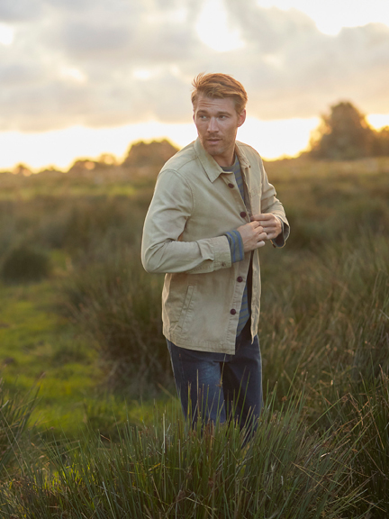 Mann im Cord-Jakko auf einer Wiese