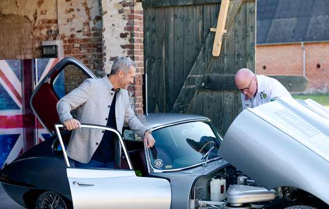 Zwei Männer beugen sich über Motor eines Oldtimers