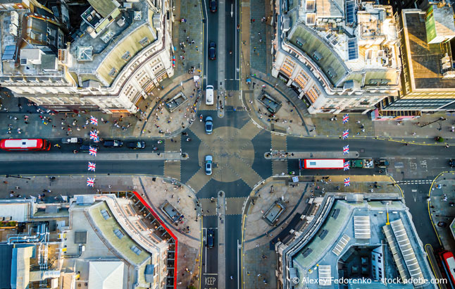 Aerial view of Oxford Circus in London with busy streets, iconic architecture, and red double-Decker buses on a clear, sunny day
