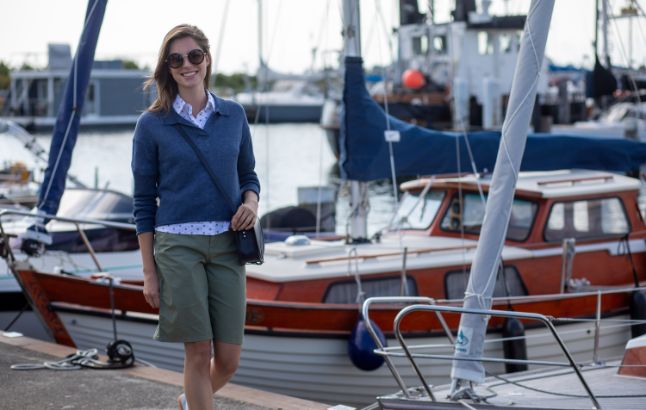 Frau in sommerlichem Outfit an kleinem Hafen