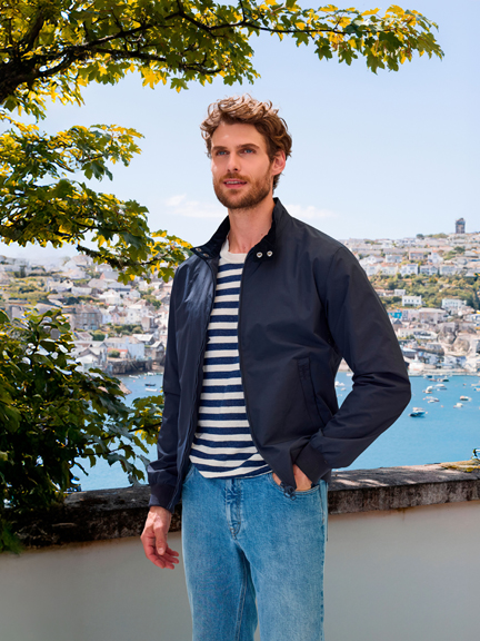 Mann im Blouson, im Hintergrund eine Bucht