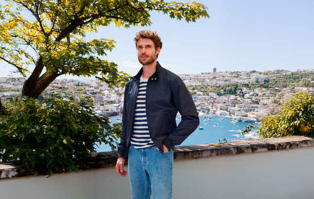 Mann vor Stadt-Kulisse mit Segel-Jachten