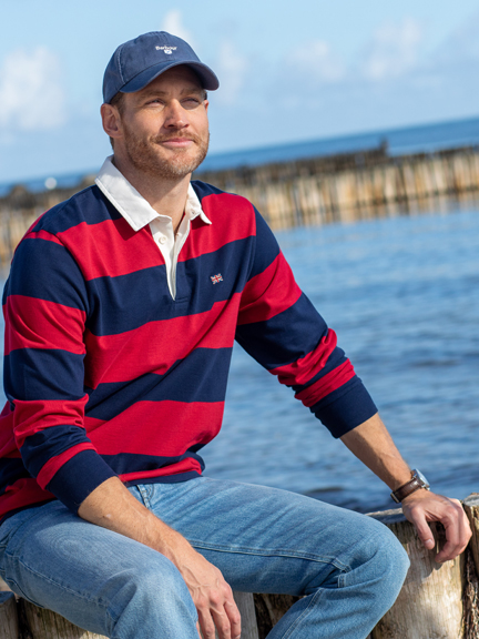 Mann im Rugbyshirt vor K�stenlandschaft