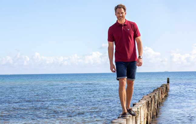 Mann balanciert über Buhnen