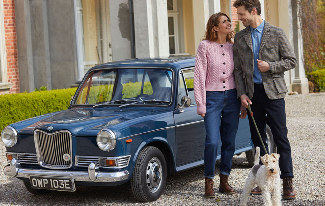 Paar in schicken Kleidern vor Oldtimer
