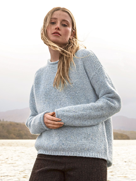 Frau im kuscheligen Pulli im Wind